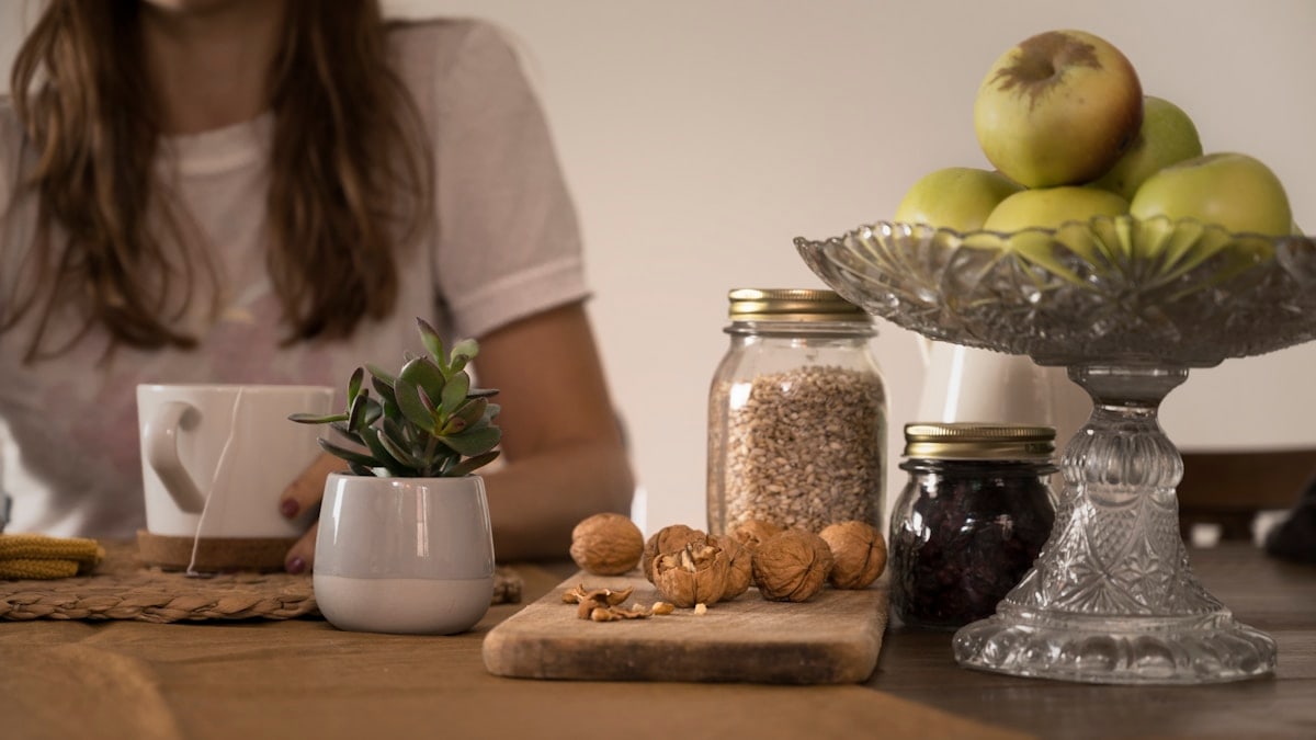 green apple fruit beside clear glass jar on brown wooden table